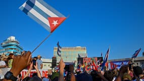 Des gens brandissent les drapeaux nationaux de Cuba lors de la commémoration du 1er mai (Fête du Travail) pour marquer la Journée internationale des travailleurs à la Tribune anti-impérialiste devant l'ambassade des États-Unis à La Havane, le 1er mai 2024.