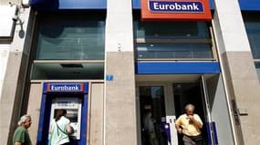 Une agence Eurobank à Athènes. Alors que Moody's a abaissé vendredi les notes de huit établissements bancaires grecs, la possibilité d'un défaut du pays sur sa dette a pris de l'ampleur, malgré l'engagement du G20 à faire le nécessaire pour empêcher que l