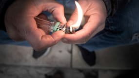 Un fumeur de crack allume sa pipe artisanale place Stalingrad à Paris, le 2 décembre 2020