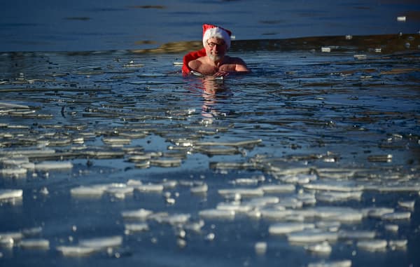 Un membre du club de natation Berliner Seehunde (les phoques de Berlin) prend le traditionnel bain de Noël au lac Orankesee lors d'une journée ensoleillée le 25 décembre 2021 à Berlin.