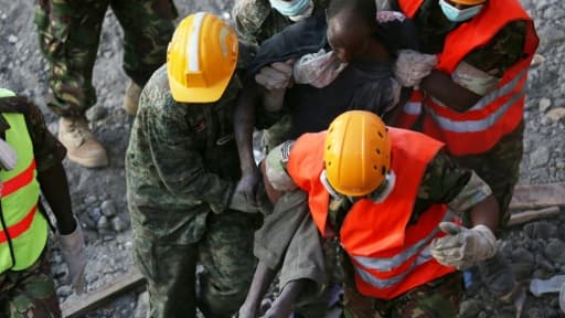 Des équipes de secours transportent un blessé après l'effondrement d'un immeuble à Nairobi, le 5 mai 2016 au Kenya