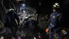 Des secouristes mènent des recherches dans les décombres d'un bâtiment détruit par une frappe russe à Zaporijjia le 21 mars 2025