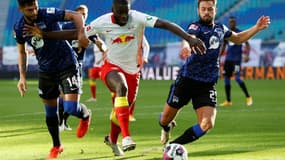Le défenseur français de Leipzig,  Dayot Upamecano, aux prises avec deux joueurs du Hertha Berlin, lors de leur match de Bundesliga, le 24 octobre 2020 à Leipzig