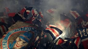 Des supporters parisiens agitent des drapeaux avant le match de football de Ligue 1 entre le Paris Saint-Germain (PSG) et le RC Strasbourg Alsace au Parc des Princes à Paris, le 19 octobre 2024