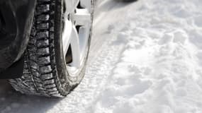 Le pneu d'une voiture roulant sur la neige (photo d'illustration).