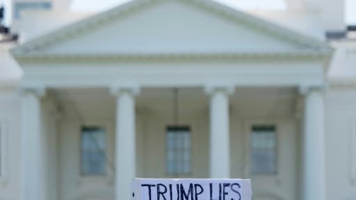 Un manifestant tient une pancarte "Trump ment" lors d'une manifestation devant la Maison-blanche, le 10 mai 2017 à Washington Un manifestant tient une pancarte "Trump ment" lors d'une manifestation devant la Maison-blanche, le 10 mai 2017 à Washington
