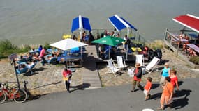 Une terrasse où sont attablés des touristes en bord de Loire à Trentemoult. 