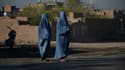 Deux Afghanes en burqa attendent pour traverser une route à Hérat, le 21 septembre 2021