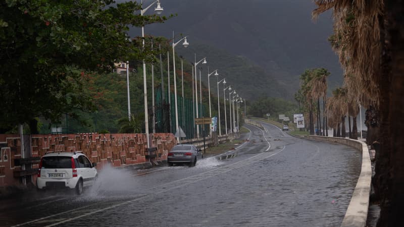 Des voitures circulent sur une route inondée suite aux fortes pluies provoquées par la tempête tropicale Ernesto, dans la ville de Basse-Terre, sur l'île française des Caraïbes de la Guadeloupe, le 13 août 2024
