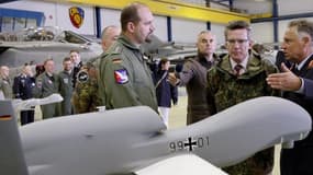 Un modèle de drone Euro-Hawk présenté au ministre allemand de la Défense, au centre.