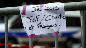 Une affichette improvisée, marquée d'un "Je suis juif, Charlie et français" et placardée lendemain de la prise d'otages, sur une barrière de sécurité devant l'épicerie casher de la porte de Vincennes, à Paris.