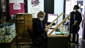Un bénévole des Restos du coeur enregistre les personnes qui viennent chercher une aide alimentaire, le 13 octobre 2020 à Paris