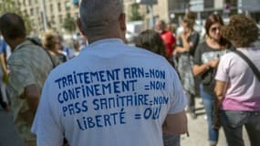 Un opposant au  pass sanitaire et à la vaccination manifeste avec d'autres soignants devant l'hôpital de la Timone à Marseille, le 5 août 2021