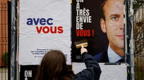 Des militants de LREM et des "Jeunes avec Macron" collent des affiches le 18 février 2022 à Issy-les-Moulineaux, en région parisienne, appelant le président à se déclarer