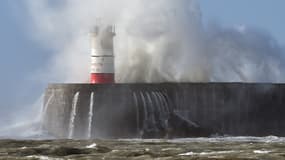 Les vagues s'écrasent au pied du phare de Newhaven, dans le sud de l'Angleterre.