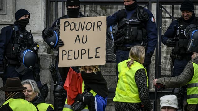 Une manifestante gilet jaune tient une pancarte "Pouvoir au peuple" à Lyon, le 15 décembre 2018. 