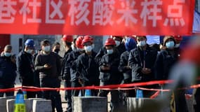 Des employés d'un chantier de construction attendent pour se faire tester au Covid-19, le 21 décembre 2021 à Xi'an, dans le nord de la Chine.