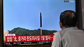 Un homme regarde un écran de télévision montrant une émission d'information avec des images d'archives d'un essai de missile nord-coréen, dans une gare de Séoul, le 4 octobre 2022.