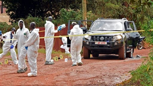 Des experts en médecine légale enquêtent sur la scène de crime du porte-parole de la police ougandaise Andrew Kaweesi, dans un faubourg de Kampala, le 17 mars 2017