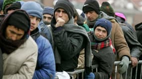 Des migrants attendent de l'aide alimentaire à Calais. Le gouvernement français va lancer une consultation pour réformer une politique d'asile "à bout de souffle" et raccourcir les délais d'examen des demandes, a annoncé samedi le ministre de l'Intérieur