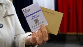 Une femme montre sa carte d'électeur, lors des élections législatives au Touquet (Pas-de-Calais), le 19 juin 2022.