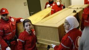 Membres du Croissant rouge syrien transportant les cercueils de Rémi Ochlik et Marie Colvin à l'université al Assad de Damas. Selon France Info, l'avion transportant les dépouilles de la journaliste américaine et du photographe français, tués le 22 févrie