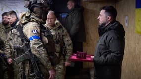 Le président ukrainien Volodymyr Zelensky (à droite) remet une médaille à un soldat ukrainien à Kupiansk, dans la région de Kharkiv le 12 décembre.