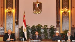 Mohamed Morsi (au centre), au palais présidentiel, au Caire. Le président égyptien a annulé samedi soir le décret qui élargissait ses prérogatives à l'origine d'une crise politique et de manifestations violentes en Egypte mais a refusé de reporter la date