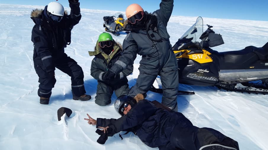 Les scientifiques devant la météorite qu'ils ont trouvée en Antarctique.
