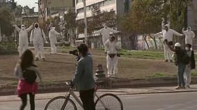 Masqués et en combinaisons, des Chiliens manifestent contre le report du référendum constitutionnel