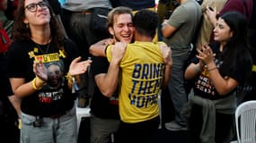 Des personnes réagissent en regardant la retransmission en direct de la libération des otages sur la place des Otages, le 13 octobre 2025 à Tel Aviv, en Israël.