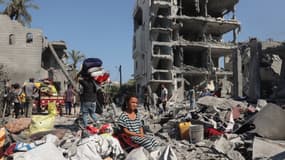 Une jeune fille palestinienne est assise alors que des personnes récupèrent leurs biens à Deir el-balah, dans le centre de la bande de Gaza, le 7 août 2024.