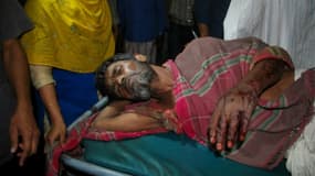 Un villageois du Bangladesh, blessé, est emmené sur une civière à l'hôpital de Chittagong, le 4 avril 2016, après des tirs de la police sur des manifestants contre un projet de construction de centrales à charbon financées par la Chine