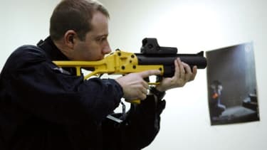 Un policier pose, le 21 mars 2008 au ministère de l'Intérieur à Paris, avec un lanceur de balles de défense