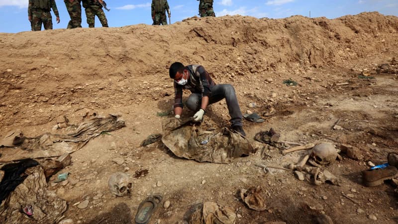 Un homme inspecte un charnier découvert par des forces kurdes en Irak et contenant des restes de membres de la communauté yézidie massacrés par Daesh, en février 2015