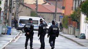 Des policiers français se tiennent debout en 2012 alors que des membres du RAID assiègent l'immeuble où est retranché Mohamed Merah