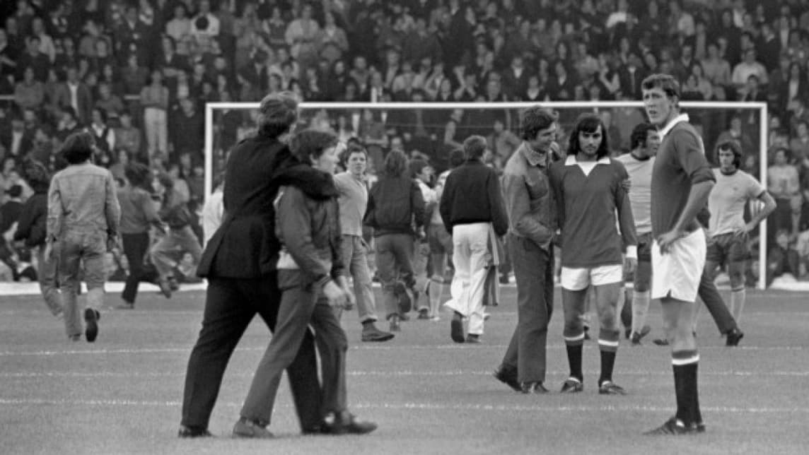 George Best (cheveuix longs, arrière plan sur la droite) était présent sur la pelouse d'Anfield pour le MU-Arsenal de 1971
George Best (cheveuix longs, arrière plan sur la droite) était présent sur la pelouse d'Anfield pour le MU-Arsenal de 1971