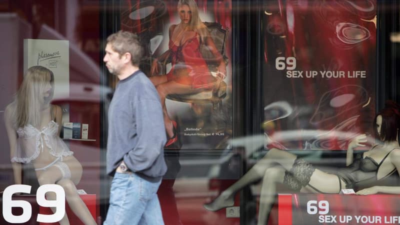 Un passant devant la vitrine d'un sex shop 