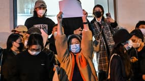 Une manifestante brandit une feuille blanche en protestation à la politique "zéro Covid" de la Chine, à Shanghaï, le 27 novembre 2022