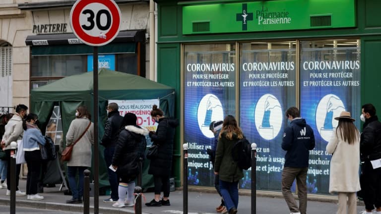 Des personnes font la queue le 6 janvier 2022 devant une pharmacie à Paris pour un test de dépistage du Covid-19