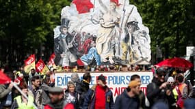 Gilets jaunes et syndicalistes à Paris le 27 avril, auprès d'une pancarte reprenant "La liberté guidant le peuple", d'Eugène Delacroix. 