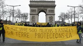 Des gilets jaunes défilent avec une banderole "On peut vivre 500 millions d'années sur Terre. Protégeons-la", le 9 mars 2019 à Paris. 