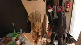Pascual inspecte un mur imbibé d'eau dans son salon de tatouage à Alfafar, dans la banlieue de Valence, en Espagne, le 28 novembre 2024, un mois après les inondations qui ont touché le sud-est du pays.