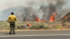Un homme observe l'important incendie en cours à Vacaville, en Californie, aux États-Unis, le 2 juillet 2025. 