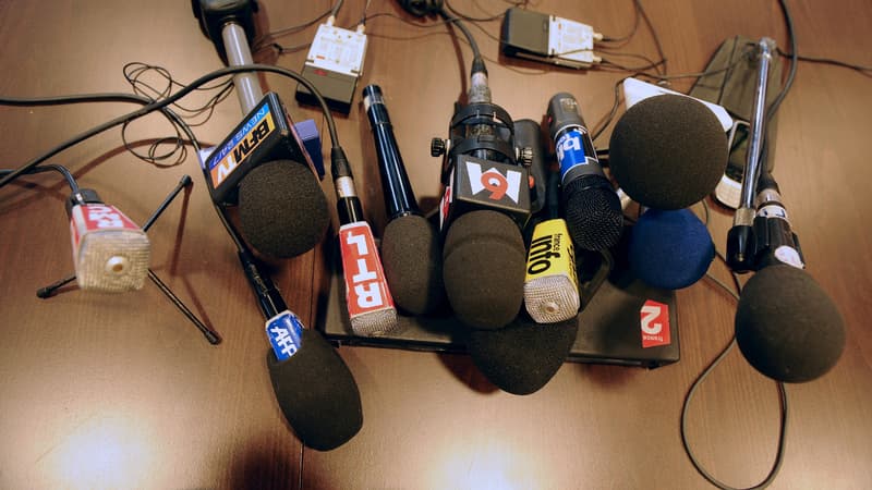 Des micros de différents médias sont posés sur une table, le 25 février 2011
