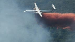 Un bombardier Dash de la Sécurité Civile largue du retardant le 18 août 2021 sur un incendie de forêt au nord de Grimaud, dans le Var