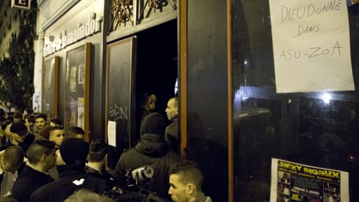 Des gens patientent devant le théâtre lundi soir.