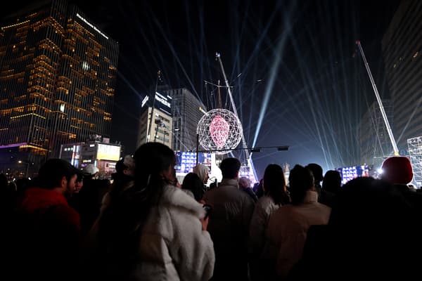 Des personnes se rassemblent pour un compte à rebours afin de célébrer le Nouvel An dans le centre de Séoul avant minuit le 31 décembre 2023.