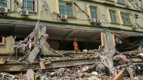 Un secouriste observe l'immeuble Sky Villa Condominium largement détruit par un séisme à Mandalay, en Birmanie, le 29 mars 2025