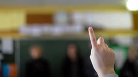Un élève en train de lever la main pour prendre la parole en salle de classe. (Photo d'illustration)